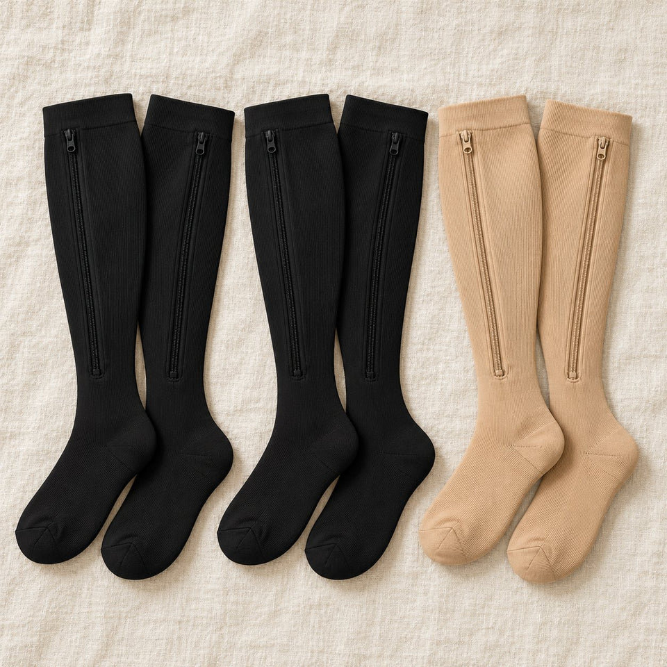 Illustration: three pairs of zip socks laid flat on linen, two black pairs and one beige pair.