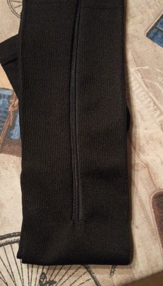 A buyer's black sock with its zip visible, laid on a bed